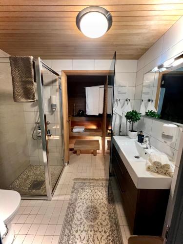 a bathroom with a shower and a sink and a toilet at Holiday Home Birdie in Naantali