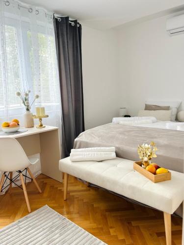 a bedroom with a bed and a table with fruit on a bench at Talia in Niš