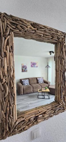 a mirror reflecting a living room with a couch at Lavendel Huisje in Herkingen