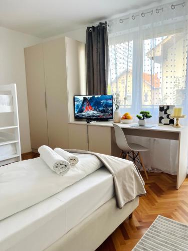 a bedroom with a bed and a desk and a window at Talia in Niš