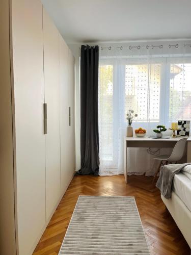 a room with a bed and a table and a window at Talia in Niš