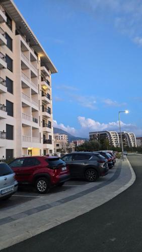 a row of cars parked in a parking lot next to a building at LIMONCELLO Apartment in Bar