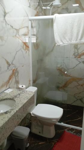a bathroom with a toilet and a sink and a shower at Brisa do Mar Guaratuba in Guaratuba