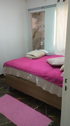a bedroom with two beds with pink sheets and a mirror at Brisa do Mar Guaratuba in Guaratuba