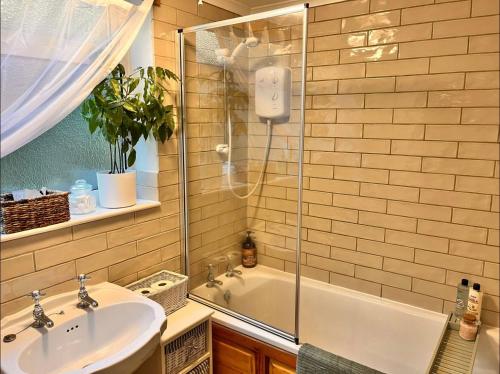 a bathroom with a shower and a sink and a tub at Traditional Country Cottage in Chew Magna