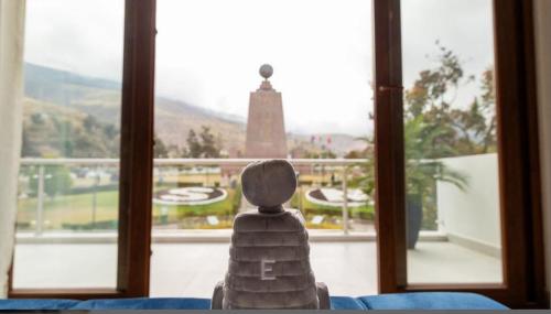 a statue sitting on a table in front of a window at Hotel Boutique Mitad Del Mundo in Quito