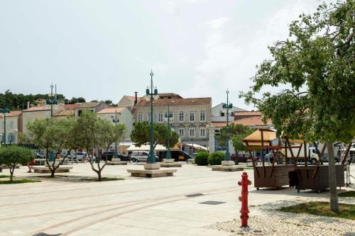 a park with a red fire hydrant in front of a building at Apartments Argemonia in Mali Lošinj