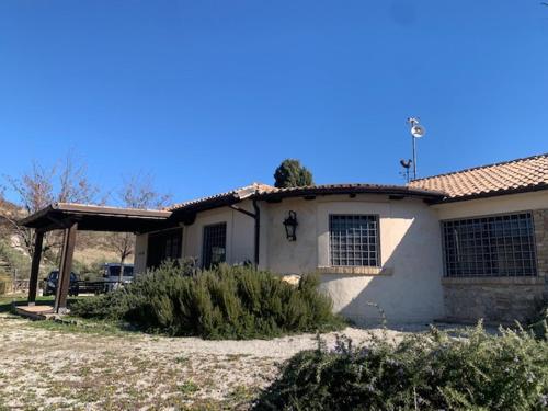 a white house with a roof and a yard at Pietra Pizzuta Country House in Torre deʼ Passeri