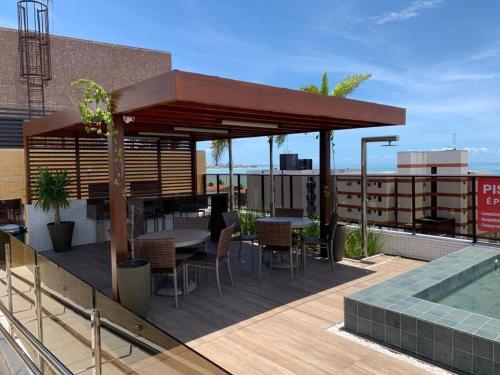 a rooftop deck with a table and chairs and a pavilion at UNO Flats 104 - 50m from the beach in João Pessoa