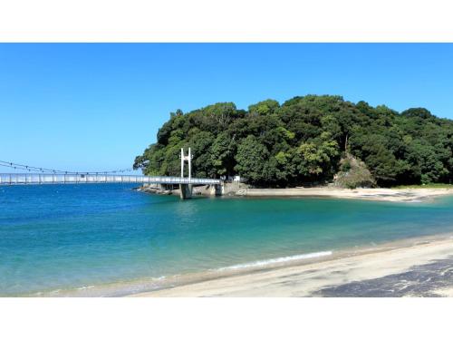a cross on a beach with a bridge in the water at Yunoko Umi To Yuyake - Vacation STAY 91661v in Minamata