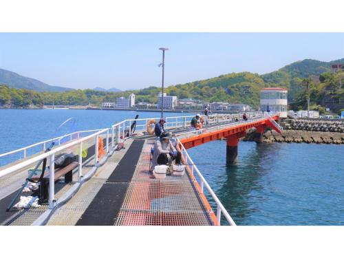 a bridge over a body of water with people on it at Yunoko Umi To Yuyake - Vacation STAY 91661v in Minamata