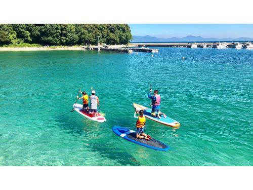 a group of people on paddle boards in the water at Yunoko Umi To Yuyake - Vacation STAY 91661v in Minamata