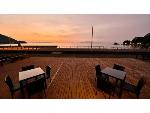 two tables and chairs on a pier at sunset at Yunoko Umi To Yuyake - Vacation STAY 91661v in Minamata