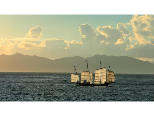a boat in the water with mountains in the background at Yunoko Umi To Yuyake - Vacation STAY 91661v in Minamata