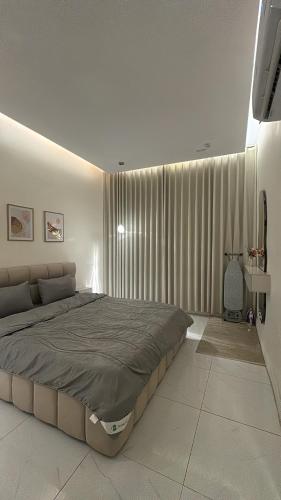 a bedroom with a large bed in front of a window at الغزال in Al Hofuf