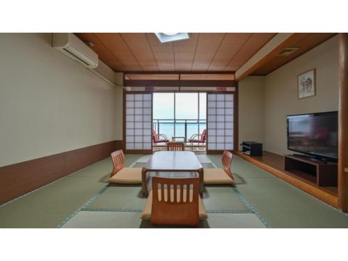 a dining room with a table and chairs and a television at Yunoko Umi To Yuyake - Vacation STAY 91661v in Minamata