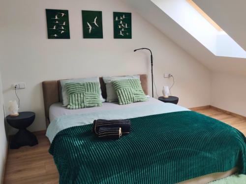 a bedroom with a bed with a green blanket at Apartmán Palackého sady - pohoda v srdci města in Písek