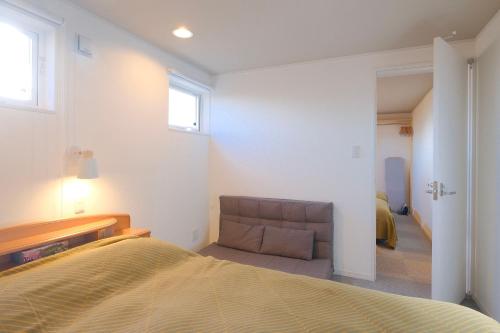 a bedroom with a bed and a couch at Rental House Towada in Towada