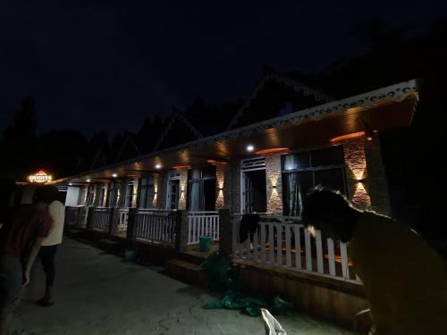 a group of people standing outside of a building at night at Drishya Stay with a view in Mangpu