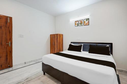 a bedroom with a large white bed with two pillows at Hotel O The Skyrise Lucknow Hotel in Kākori