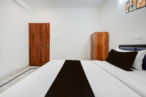 a bedroom with a bed with a black and white comforter at Hotel O The Skyrise Lucknow Hotel in Kākori