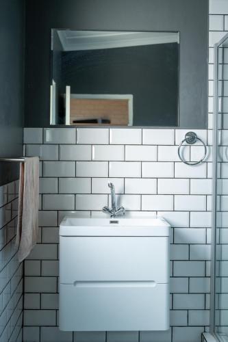 a bathroom with a white sink and a mirror at The Palms Guest House in Hopetown