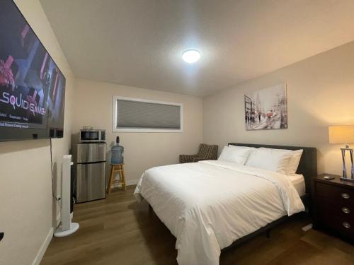 a bedroom with a bed and a flat screen tv at Lumi Deluxe in Saskatoon