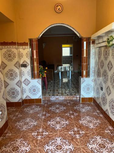 a room with a tile floor and a dining room at Bellahcen house in Nador