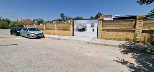 un'auto parcheggiata in un parcheggio vicino a una recinzione di Resort Circuito Sevilla a Carmona