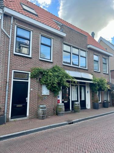 a brick building with windows and potted plants on a street at Shortstay Sneeker Munt in Sneek