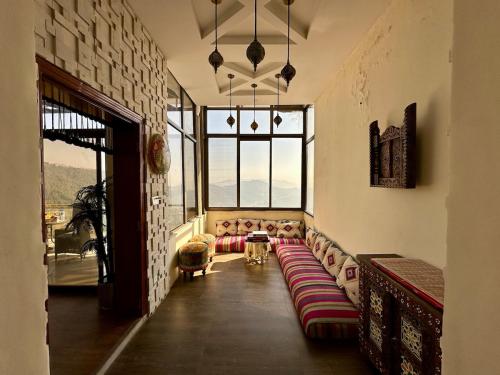 a living room with a couch and a large window at Mountain View Murree in Murree