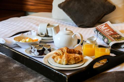 a tray with breakfast foods on a bed at Royal Enclave Hotel in Lahore