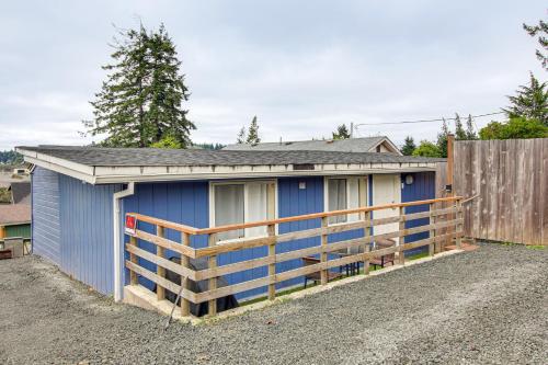a blue shed with a wooden fence in front of it at Walk to Mingus Park Quaint Escape with Private Yard in Coos Bay