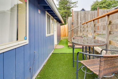 a patio with a table and chairs and a blue house at Walk to Mingus Park Quaint Escape with Private Yard in Coos Bay
