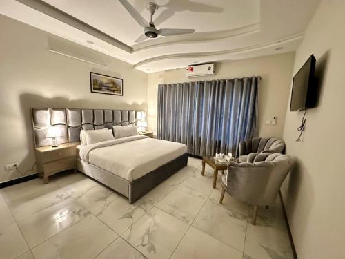 a hotel room with a bed and a chair at The Bless inn Hotel in Islamabad