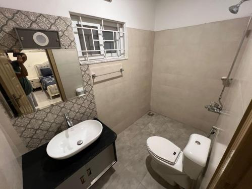 a bathroom with a toilet and a sink and a mirror at The Bless inn Hotel in Islamabad