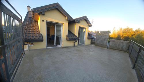 a house with a large patio next to a fence at Apartament 45 in Olszewnica Nowa