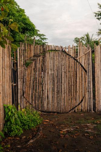 a wooden fence with a tree in front of it at Bambuk Bio Chalet Uvita Beach Front in Uvita