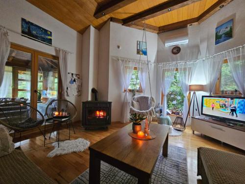 a living room with a fireplace and a tv at Vikendica Šehić in Zavidovići