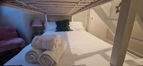 a bedroom with a bed with towels on it at Amazing Central Windsor Flat Contractors welcome in Windsor