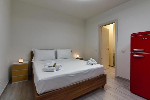 ein Schlafzimmer mit einem Bett mit Handtüchern und einem roten Kühlschrank in der Unterkunft Dream Suites Sesto Centro in Sesto San Giovanni