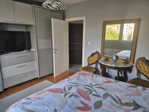 una camera da letto con un letto, uno specchio e un tavolo di Eleni Apartment a Bitola