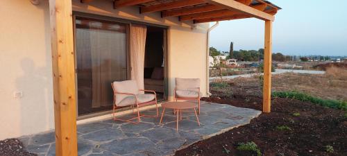 two chairs and a table on a patio at שיר ערש in Giv'at Yo'av