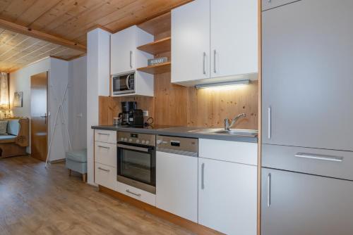 a kitchen with white cabinets and a sink at Pleschinhof in Velden am Wörthersee