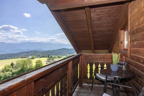 a balcony with a table and a view of the mountains at Pleschinhof in Velden am Wörthersee