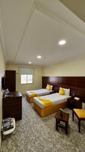 a hotel room with two beds and a table at فندق مضياف in Makkah