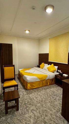 a hotel room with two beds and a chair at فندق مضياف in Makkah