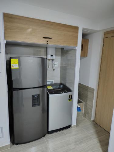 a kitchen with a refrigerator in a room at Apartamento Moderno y Tranquilo con Vista a la Montaña in Cali