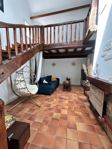 a living room with a staircase and a blue couch at Maison aux portes de Dijon à la campagne in Izier