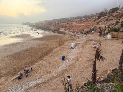 a group of people on a sandy beach at sunset taghazout in Taghazout